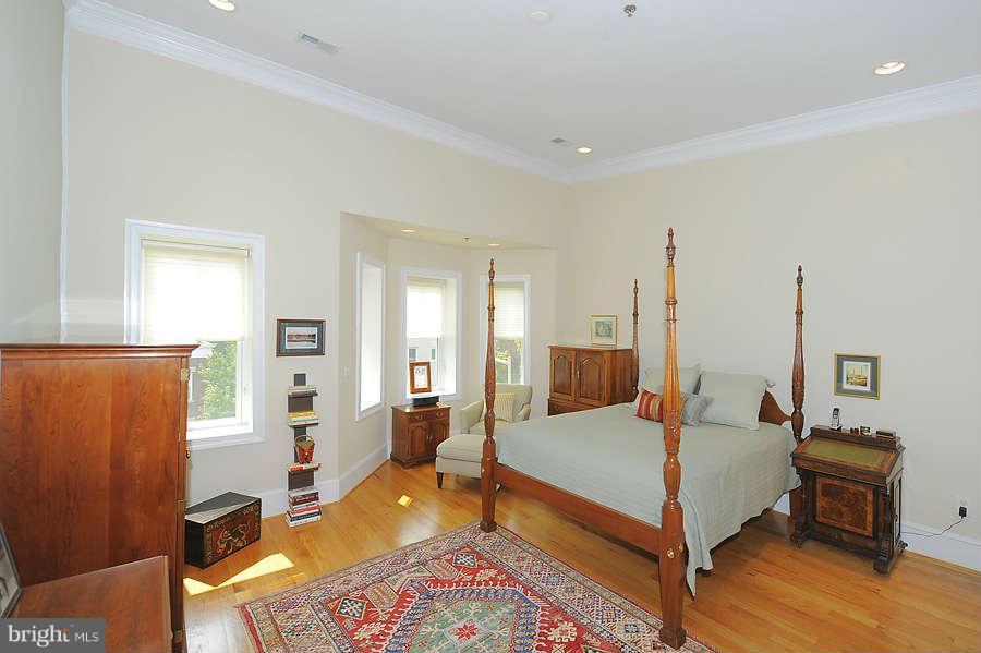 629 4th Street Northeast, Unit 3 Washington, DC 20002 - Photo 22 of 30 a spacious bedroom with a bed a table and painting on the wall