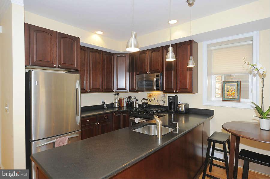 629 4th Street Northeast, Unit 3 Washington, DC 20002 - Photo 4 of 30 a kitchen with granite countertop a sink stove and refrigerator