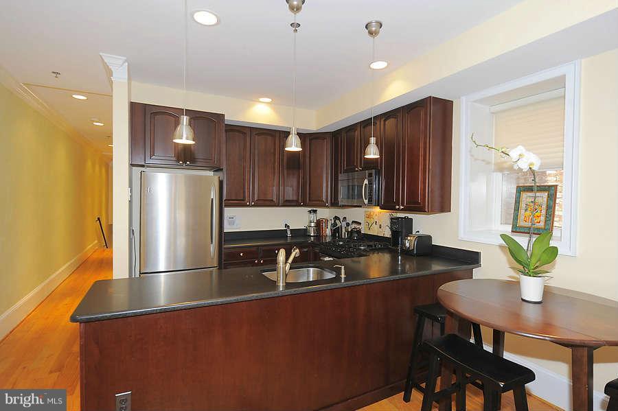 629 4th Street Northeast, Unit 3 Washington, DC 20002 - Photo 6 of 30 a kitchen with sink refrigerator dining table and chairs