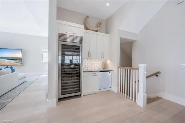 a view of a hallway with entryway wooden floor and cabinet