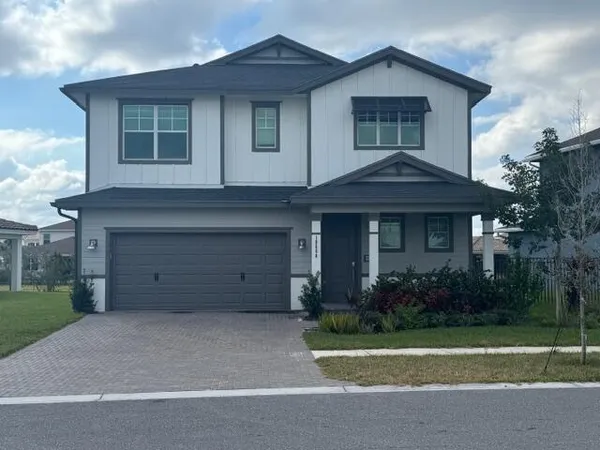 a front view of a house with a garden and garage