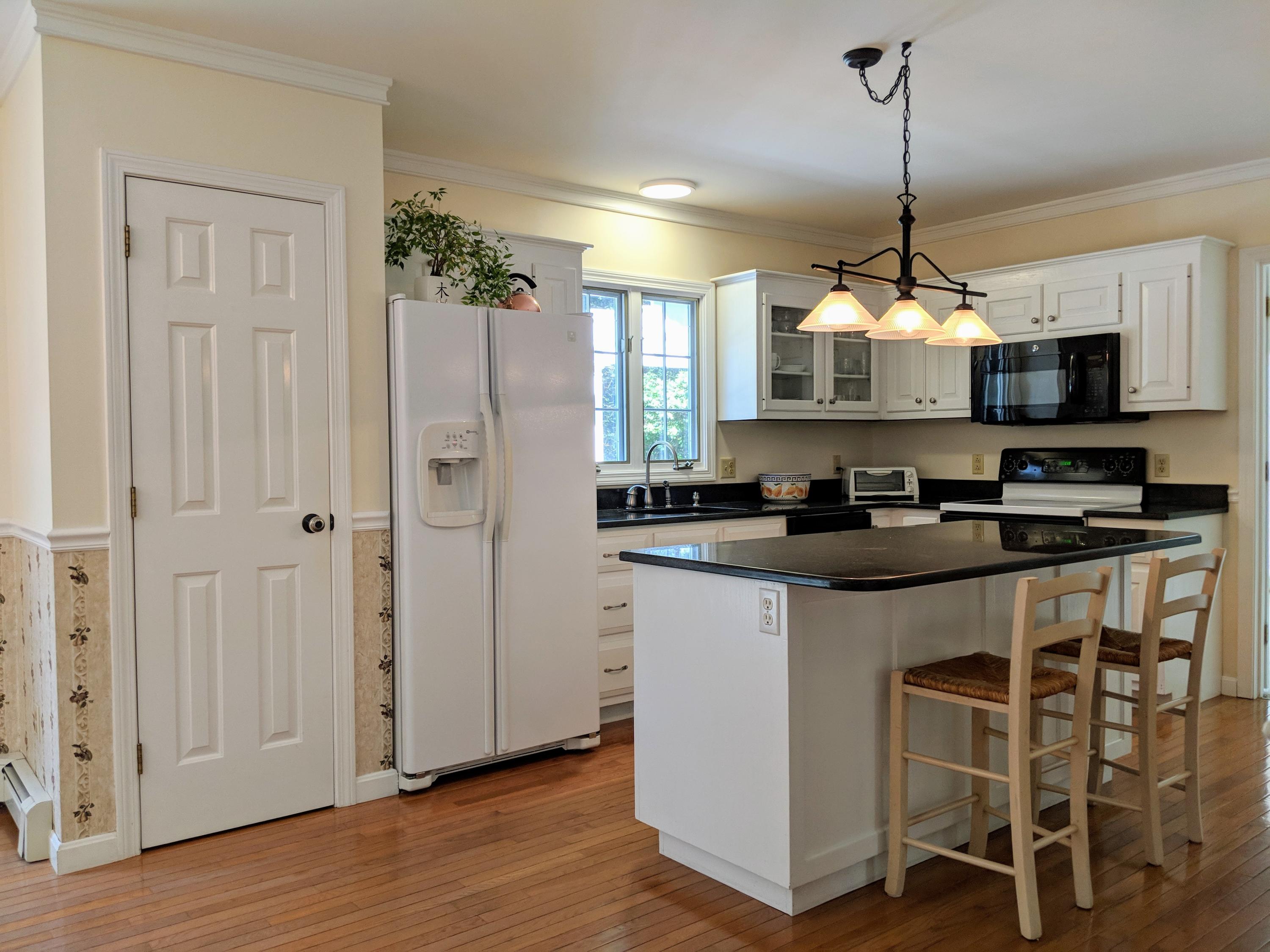33 Highfield Drive Sandwich, MA 02563 - Photo 6 of 16 a kitchen with kitchen island granite countertop a stove a sink and a wooden floor