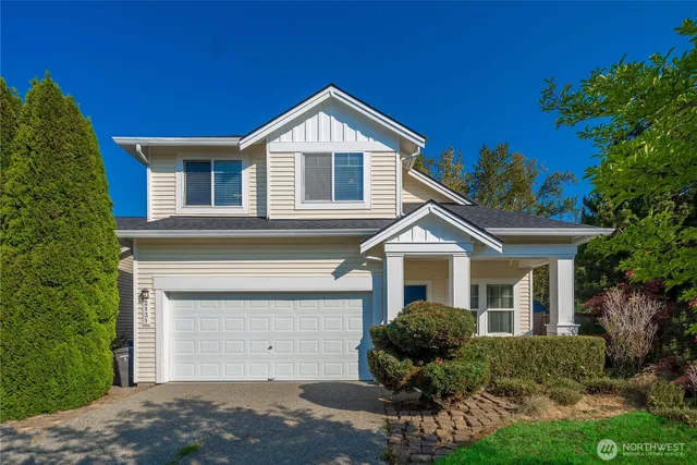 a front view of a house with yard and green space