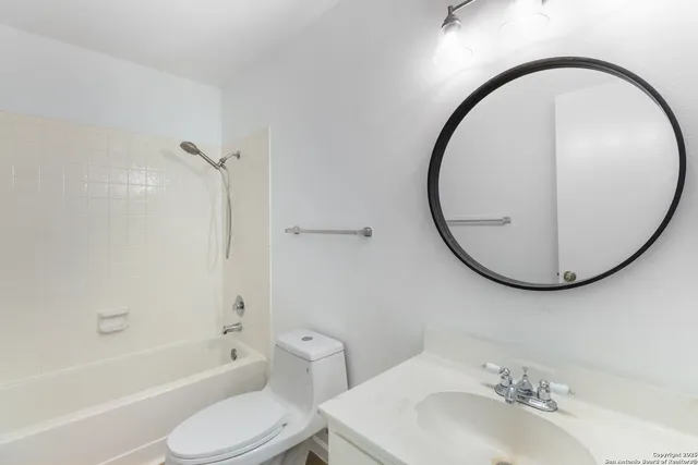 a bathroom with a sink a toilet and a mirror