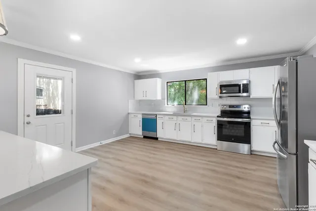 a kitchen with granite countertop a refrigerator and a stove