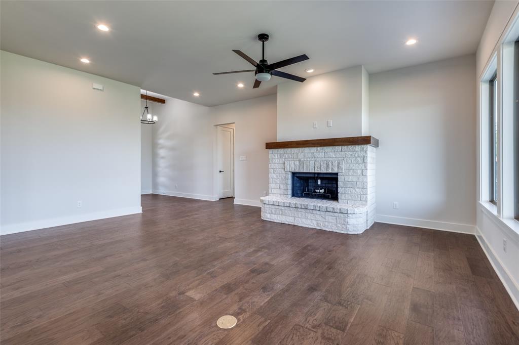 815 Evergreen Way Nevada, TX 75173 - Photo 11 of 38 an empty room with wooden floor fireplace and windows
