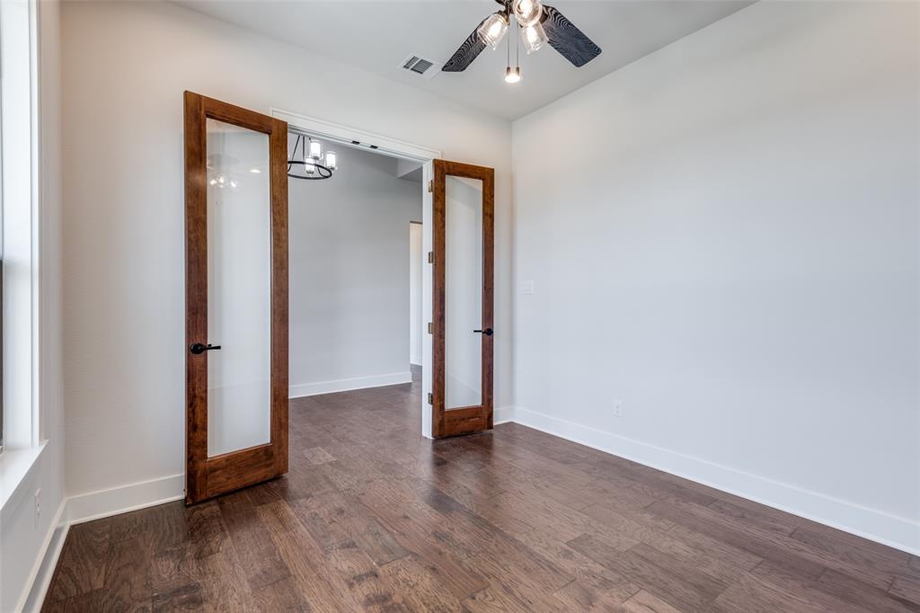 815 Evergreen Way Nevada, TX 75173 - Photo 28 of 38 an empty room with wooden floor and a ceiling fan