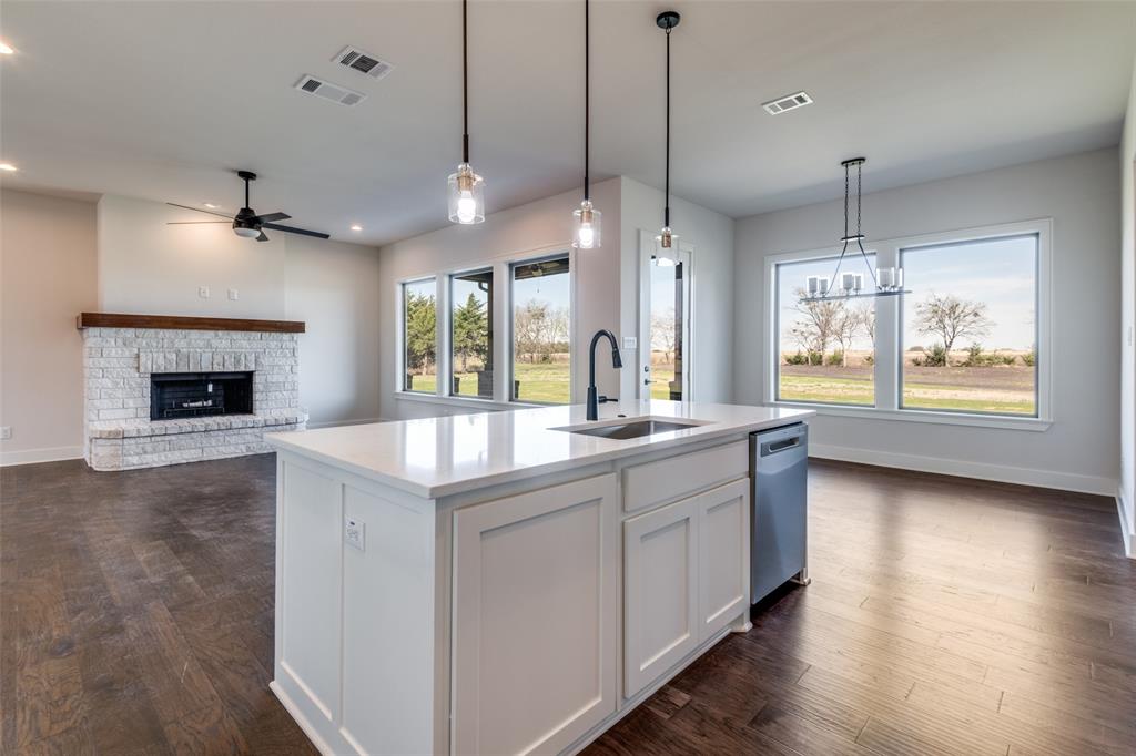 815 Evergreen Way Nevada, TX 75173 - Photo 7 of 38 a kitchen with kitchen island a sink stainless steel appliances and a fireplace