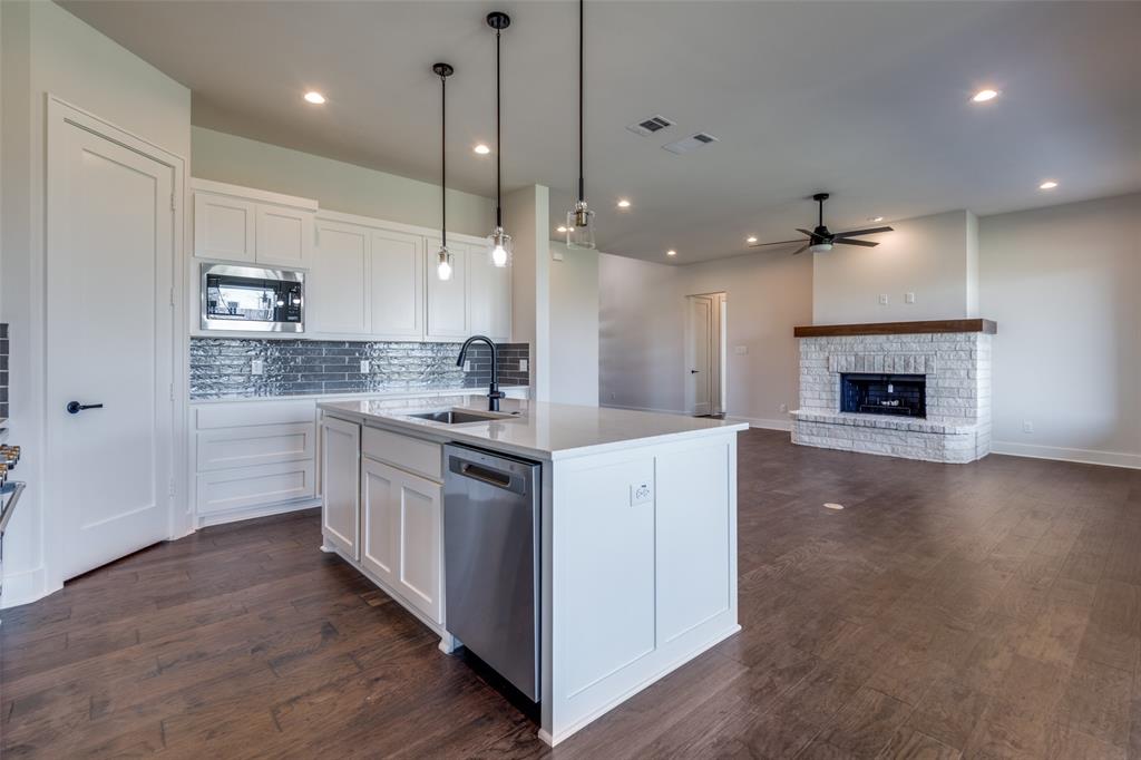 815 Evergreen Way Nevada, TX 75173 - Photo 8 of 38 a large kitchen with granite countertop a stove top oven a sink a dining table and chairs with wooden floor