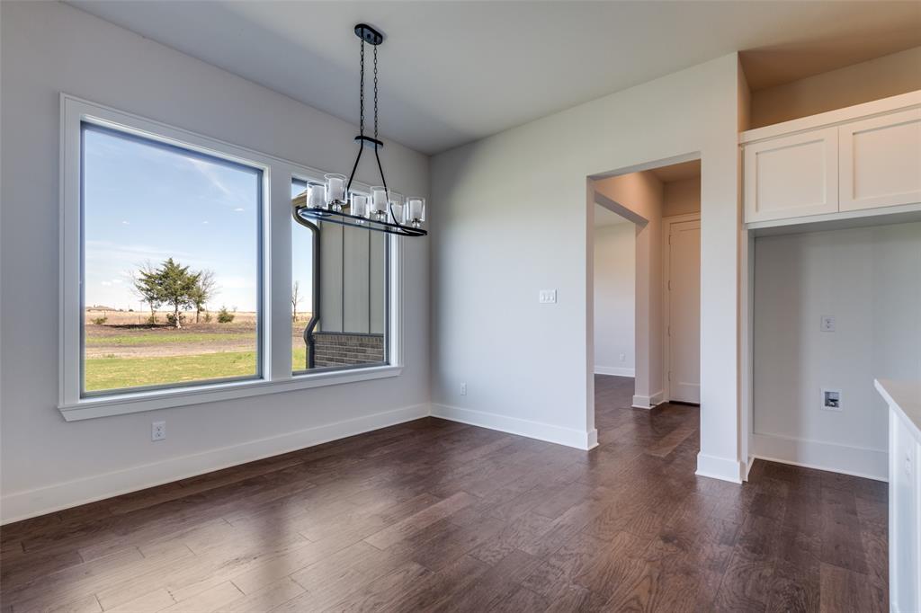 815 Evergreen Way Nevada, TX 75173 - Photo 10 of 38 a view of an empty room with wooden floor and a window