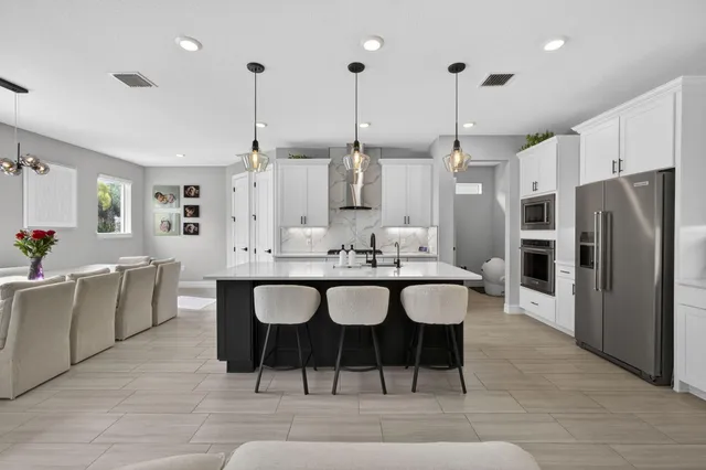 a large kitchen with a table and chairs