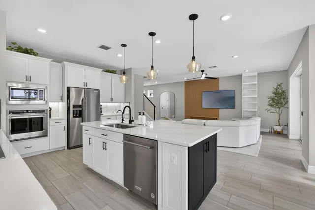 a kitchen with kitchen island a sink stainless steel appliances and cabinets