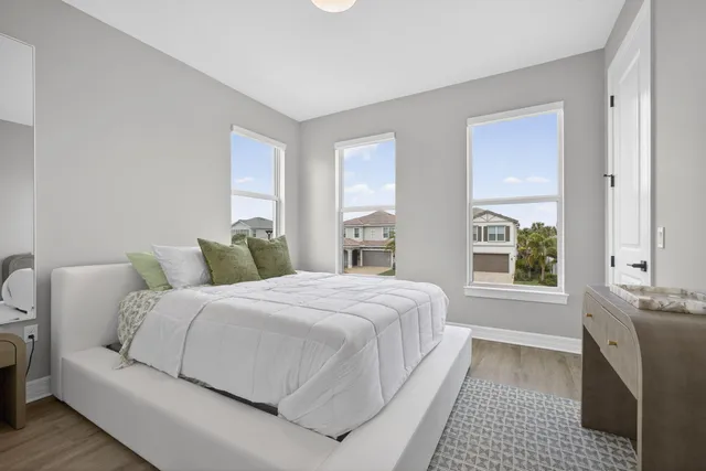 a bedroom with a large bed a fireplace and windows