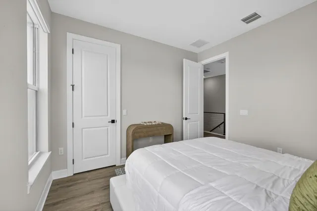 a bedroom with a bed and wooden floor
