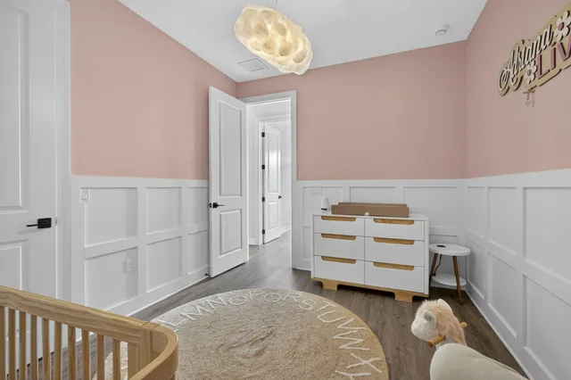 a room with a baby crib and a dresser