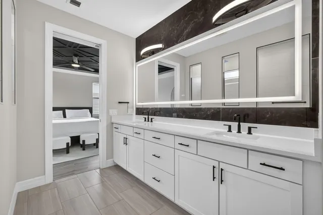 a en suite bathroom with double vanity and mirrors