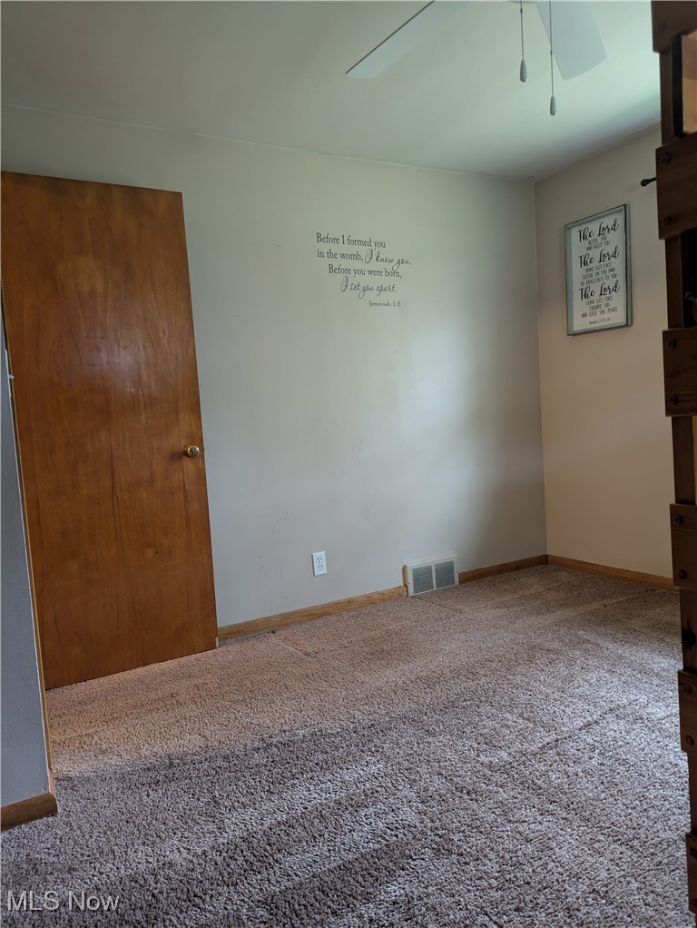 9581 Colton Road Windham, OH 44288 - Photo 21 of 26 Carpeted spare room featuring visible vents, baseboards, and ceiling fan