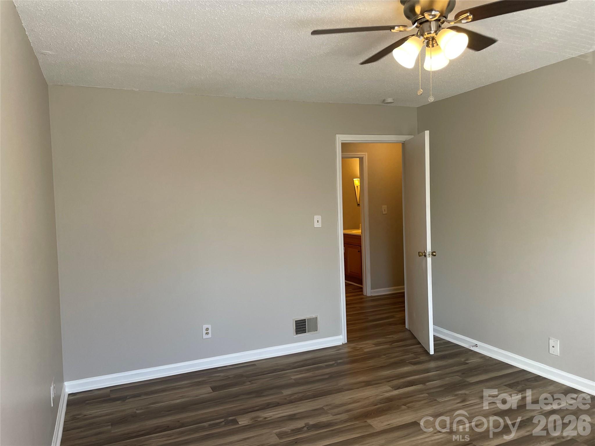 118 Ross Street, Unit B2 Morganton, NC 28655 - Photo 12 of 19 a view of an empty room with wooden floor and a ceiling fan