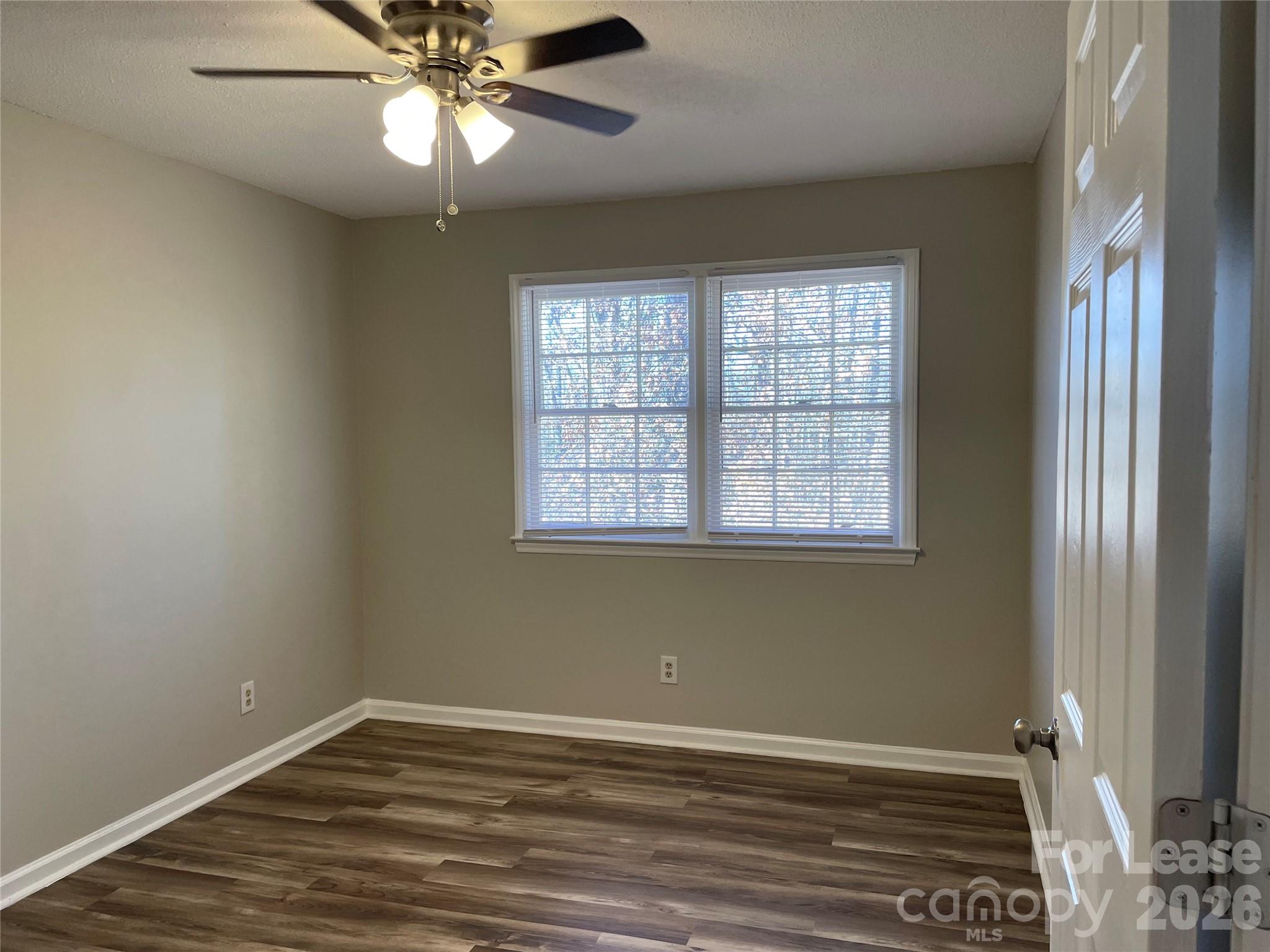 118 Ross Street, Unit B2 Morganton, NC 28655 - Photo 16 of 19 an empty room with wooden floor fan and windows