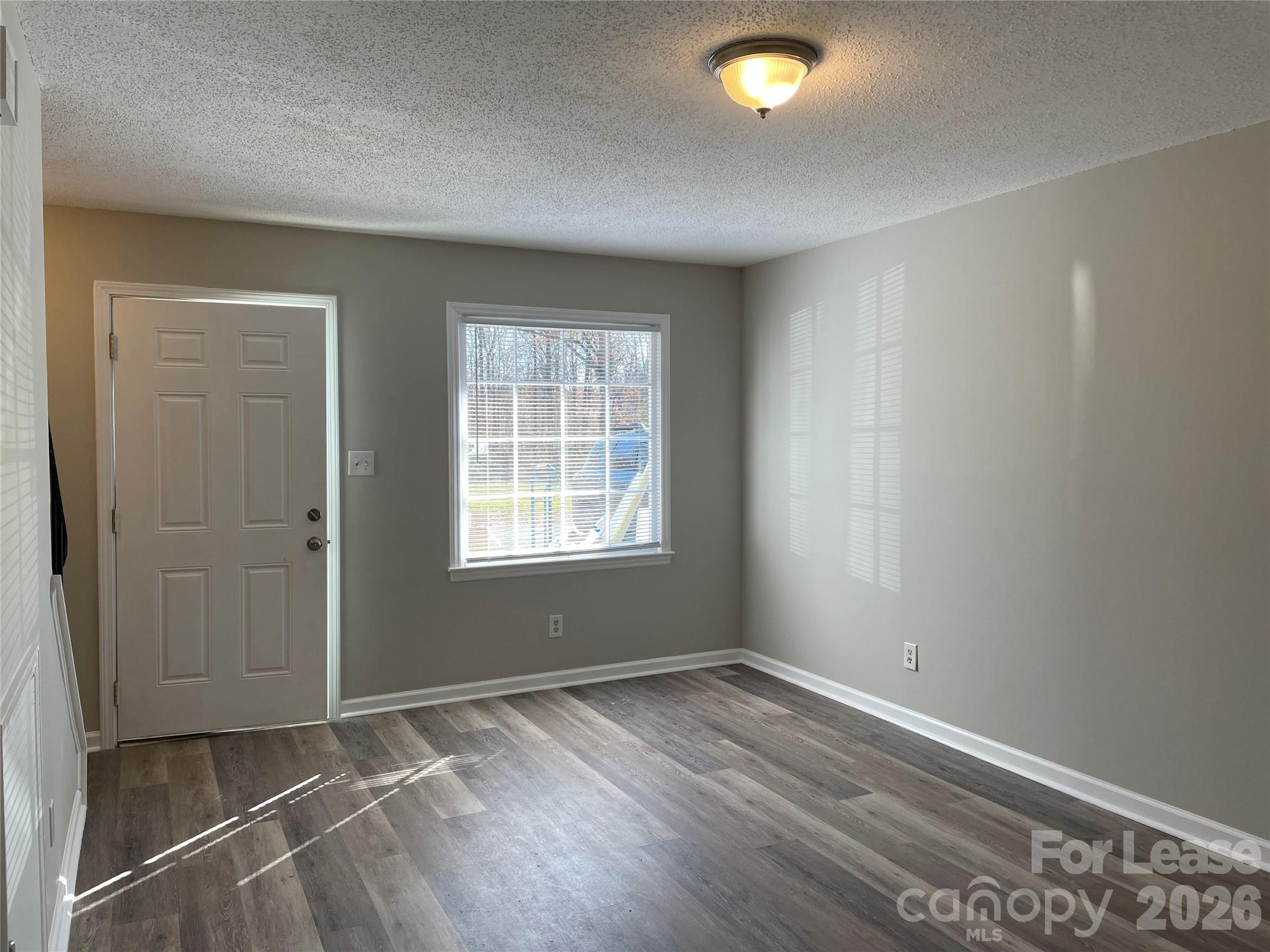 118 Ross Street, Unit B2 Morganton, NC 28655 - Photo 3 of 19 an empty room with wooden floor and windows