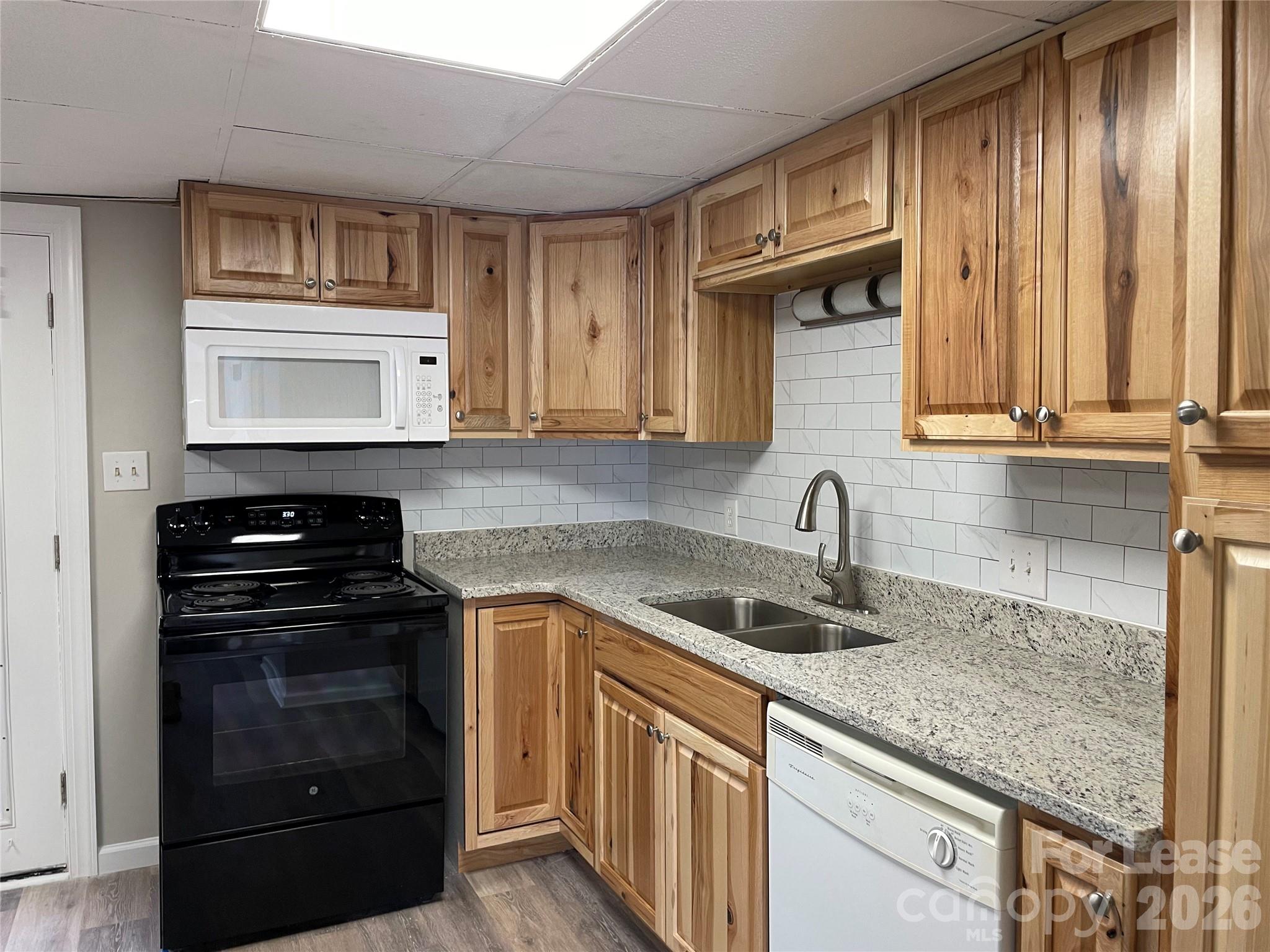 118 Ross Street, Unit B2 Morganton, NC 28655 - Photo 4 of 19 a kitchen with granite countertop a sink stove and cabinets