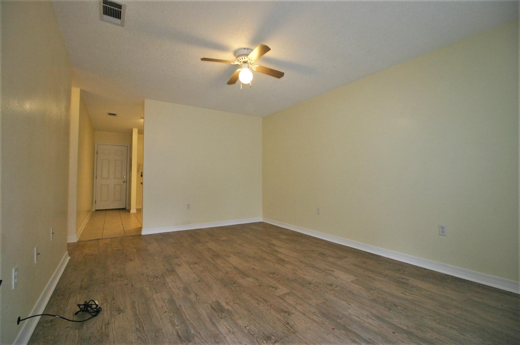 532 Brock Avenue Crestview, FL 32539 - Photo 2 of 10 an empty room with wooden floor and fan