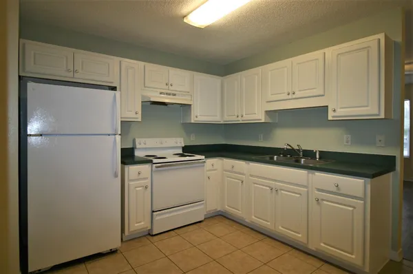 a kitchen with white cabinets and white appliances