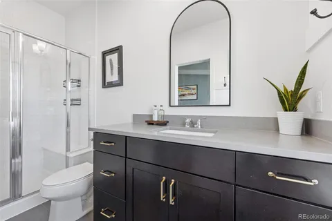 a bathroom with a granite countertop sink a toilet and with mirror