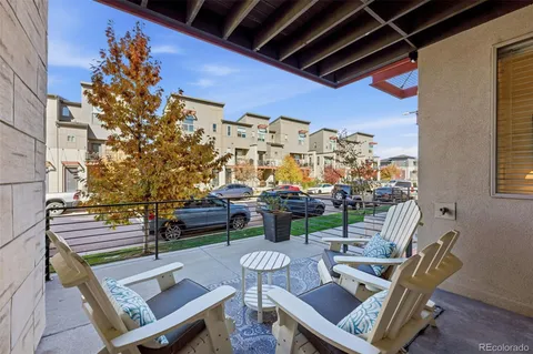 a view of a patio with a dining table and chairs with wooden floor