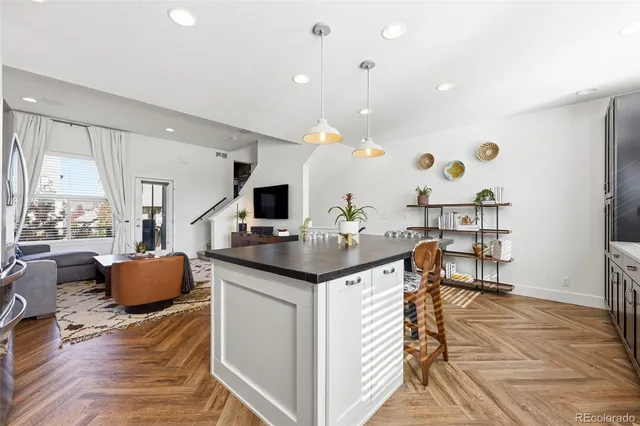 a kitchen with stainless steel appliances kitchen island granite countertop a table and chairs in it