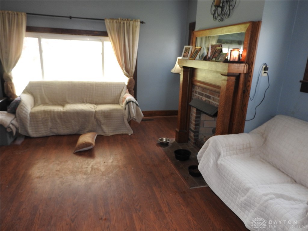 2105 East Loy Road Piqua, OH 45356 - Photo 15 of 26 This inviting living space features warm flooring and a charming fireplace.