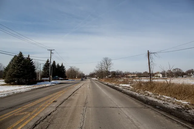 a swimming pool with a yard and trees in the background