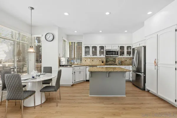 a kitchen with a table chairs refrigerator and microwave