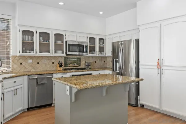 a kitchen with stainless steel appliances granite countertop a refrigerator and a sink