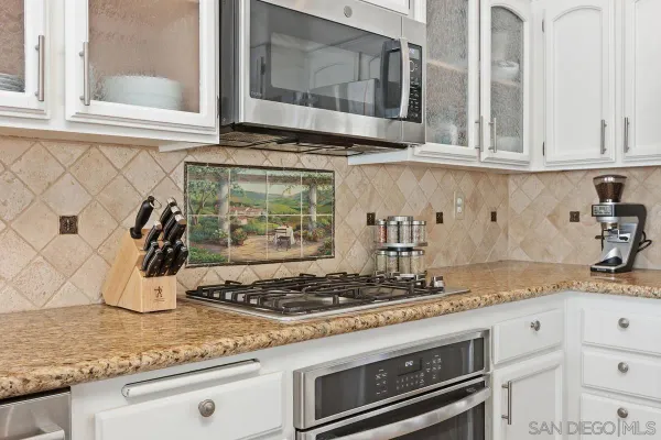 a kitchen with granite countertop stainless steel appliances stove and sink