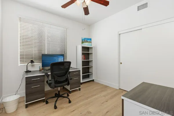 a view of a workspace with furniture and a window