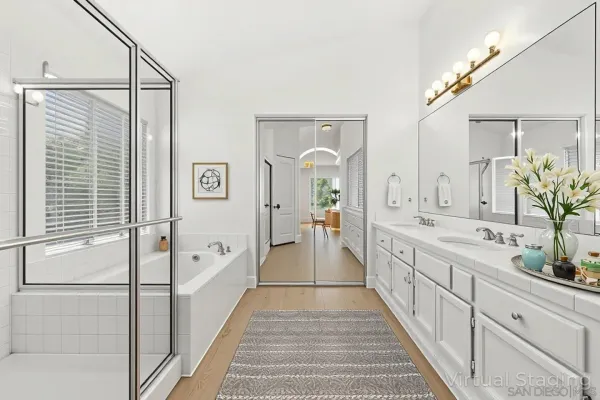 a spacious bathroom with a double vanity sink and mirror