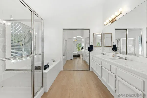 a spacious bathroom with a double vanity sink and a large mirror