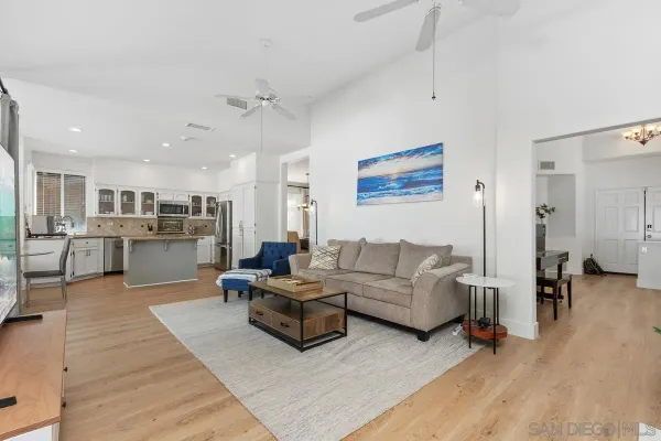 a living room with furniture and view of kitchen