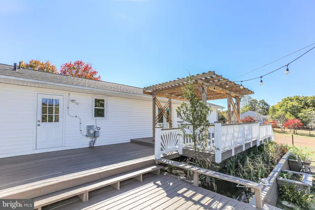 an empty room with chandelier fan and windows