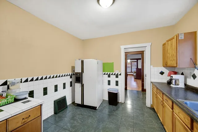 a view of a kitchen with fridge and workspace