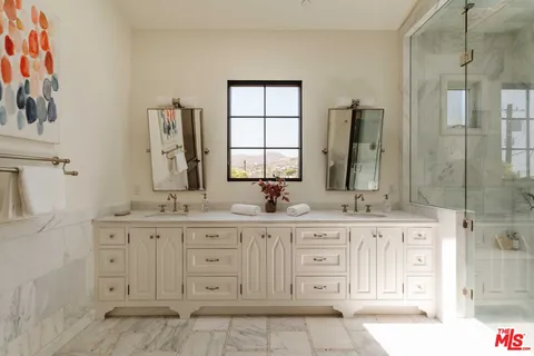 a bathroom with a granite countertop double vanity sink a mirror a vanity and a bathtub