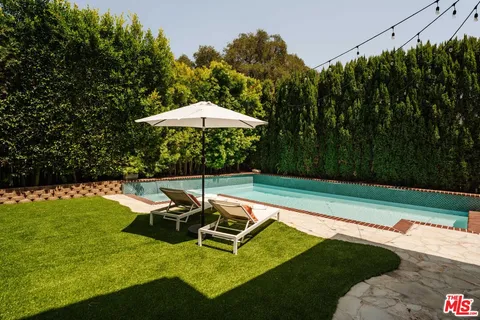a view of a swimming pool with a garden and trees