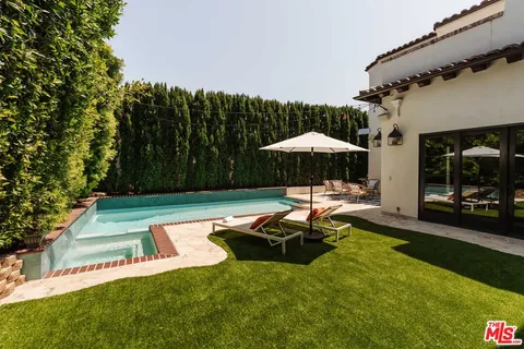 a view of a swimming pool with a table and chairs under an umbrella