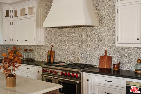a kitchen with a stove and white cabinets