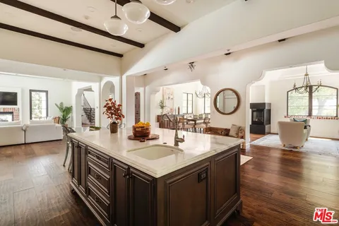 a kitchen with a sink and a stove with wooden floor