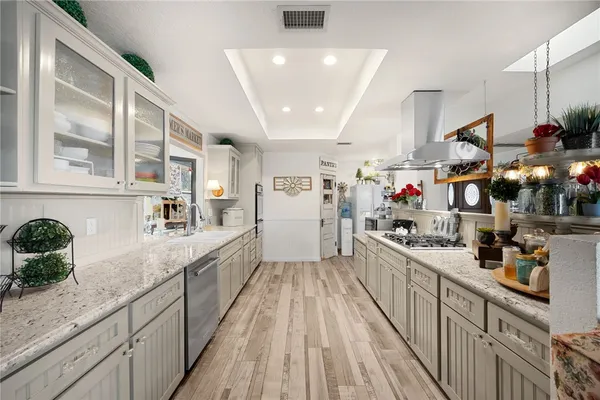 a kitchen with stainless steel appliances granite countertop a stove a sink and a refrigerator
