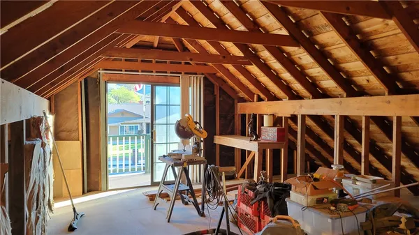a view of an empty room with wooden floor and stairs
