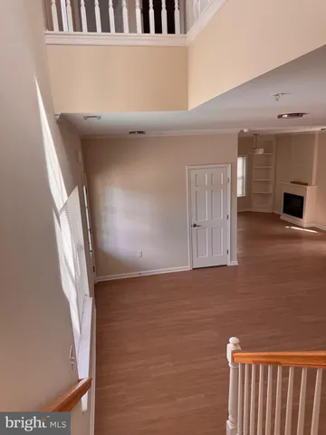 a view of a hallway with wooden floor and entryway
