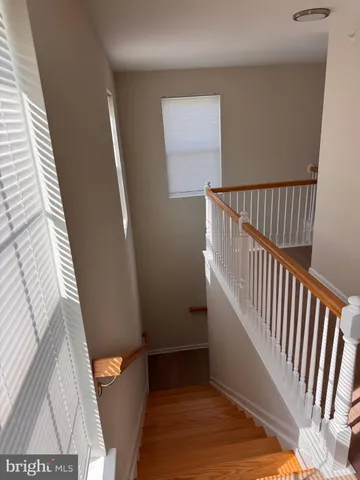 a view of a hallway with wooden floor and stairs